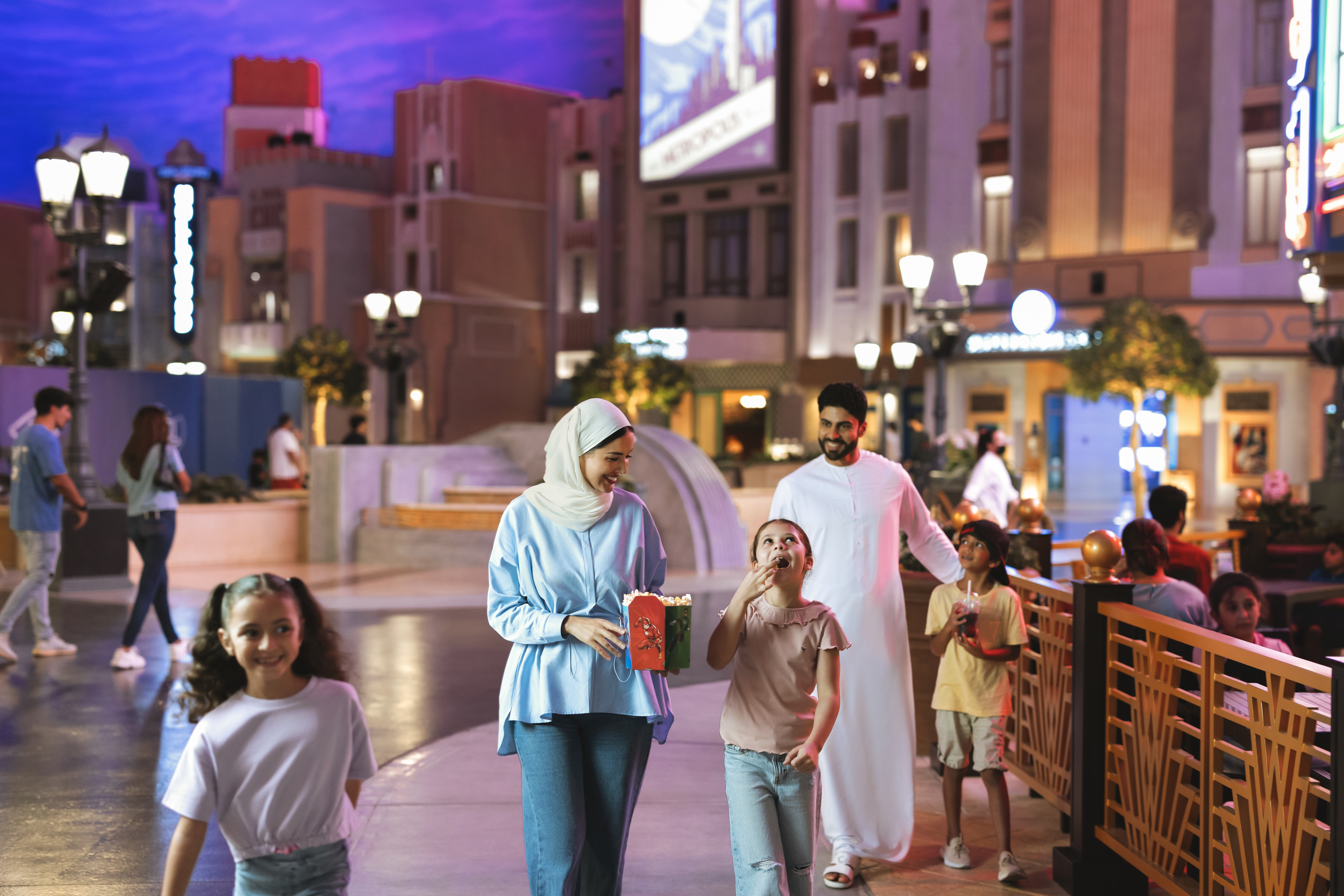 Mother and daugher eating popcorn and walking through the Warner Bros Themepark interior