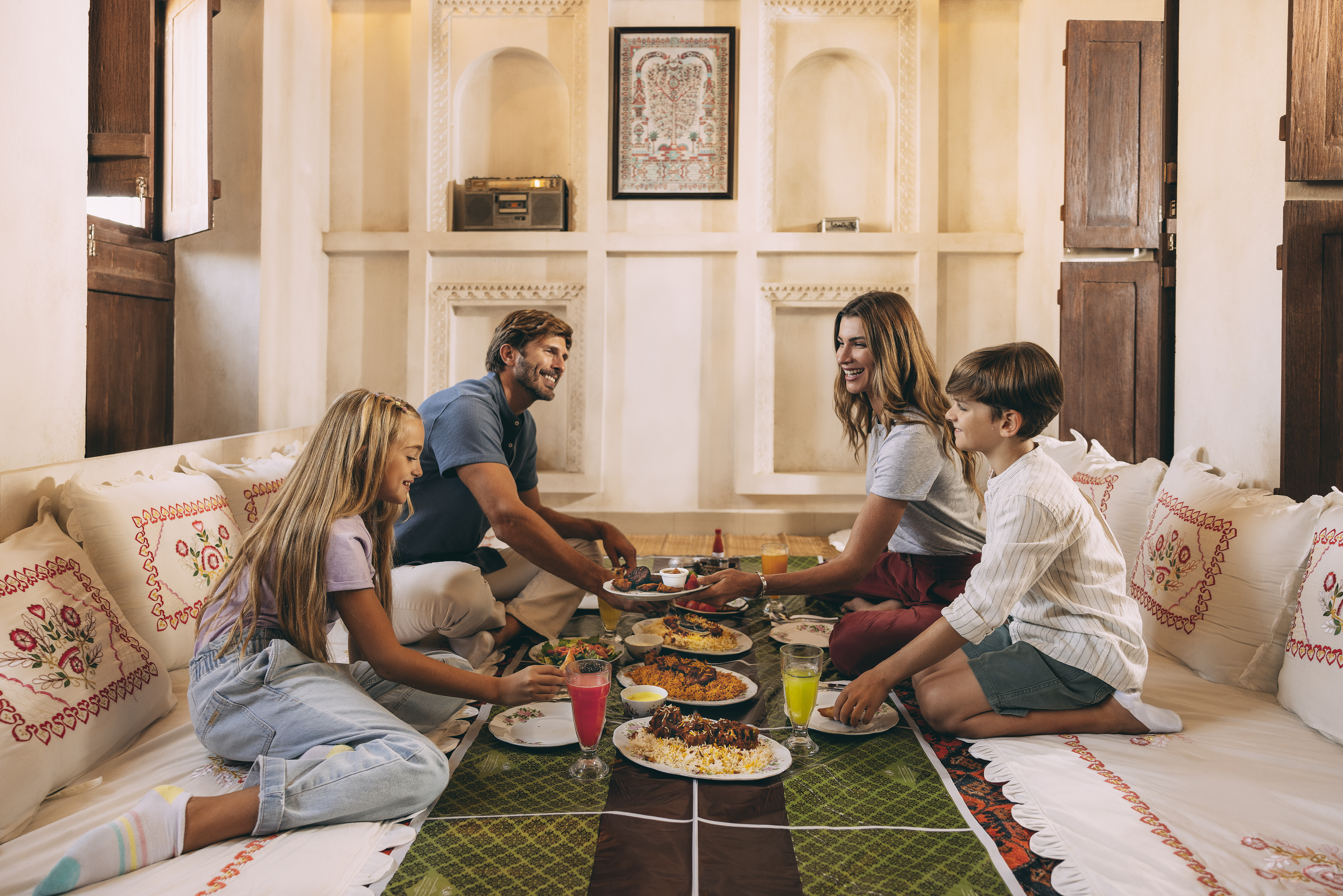 A family enjoying a traditional Emirati meal together in a cozy dining setting.