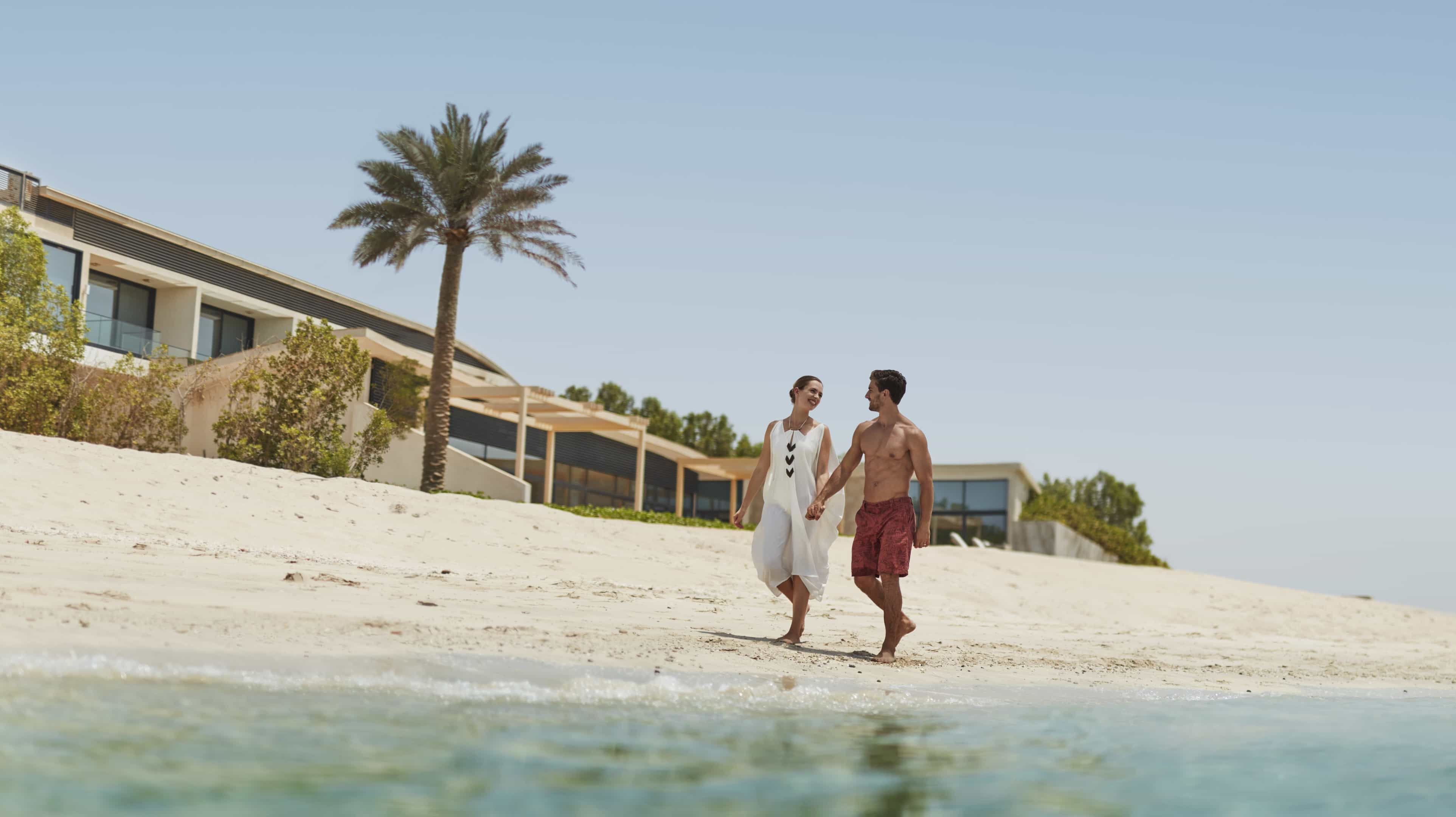 Western couple walking on the beach at Nurai Island