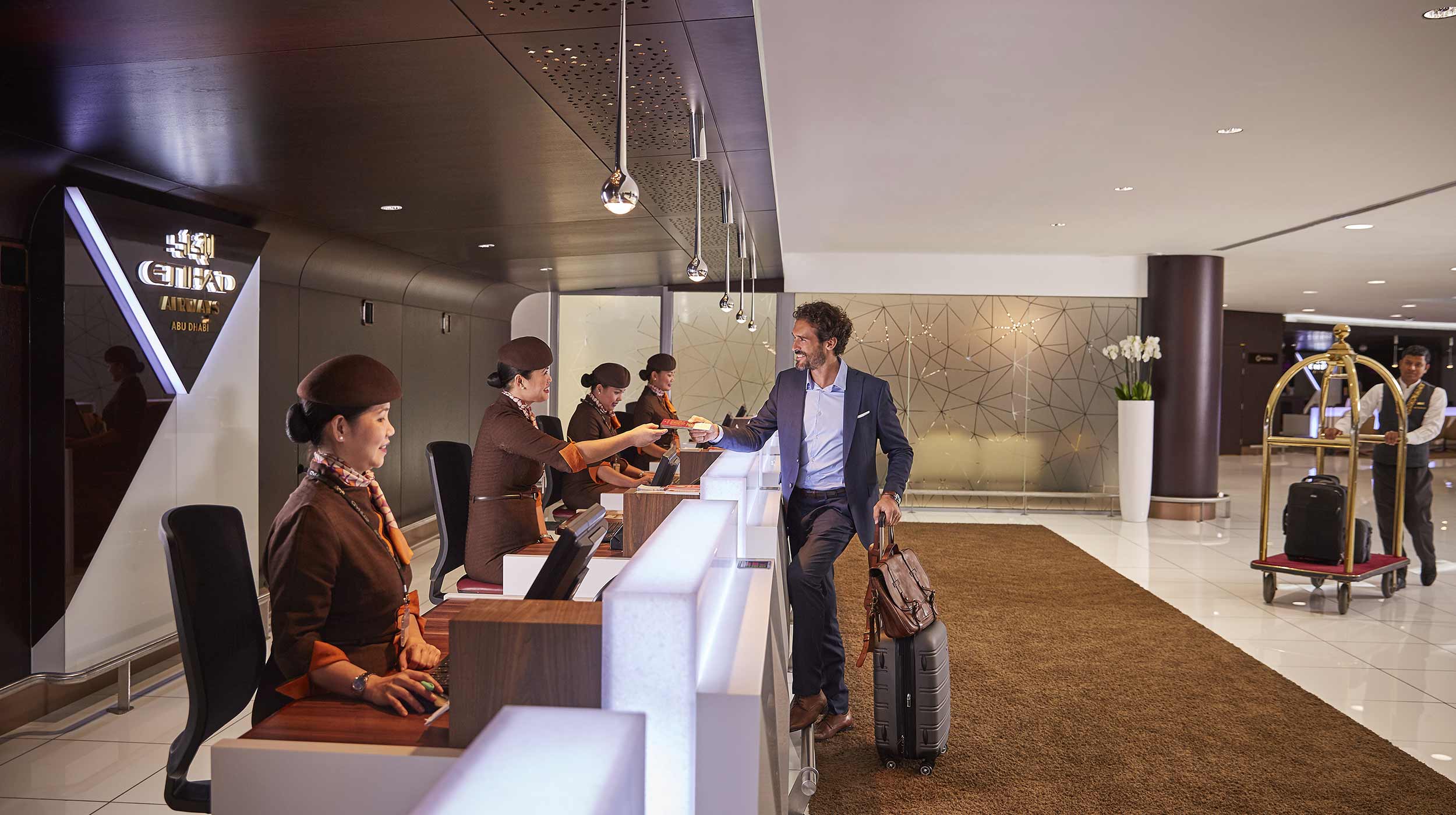 Business man checking into Abu Dhabi International Airport lounge