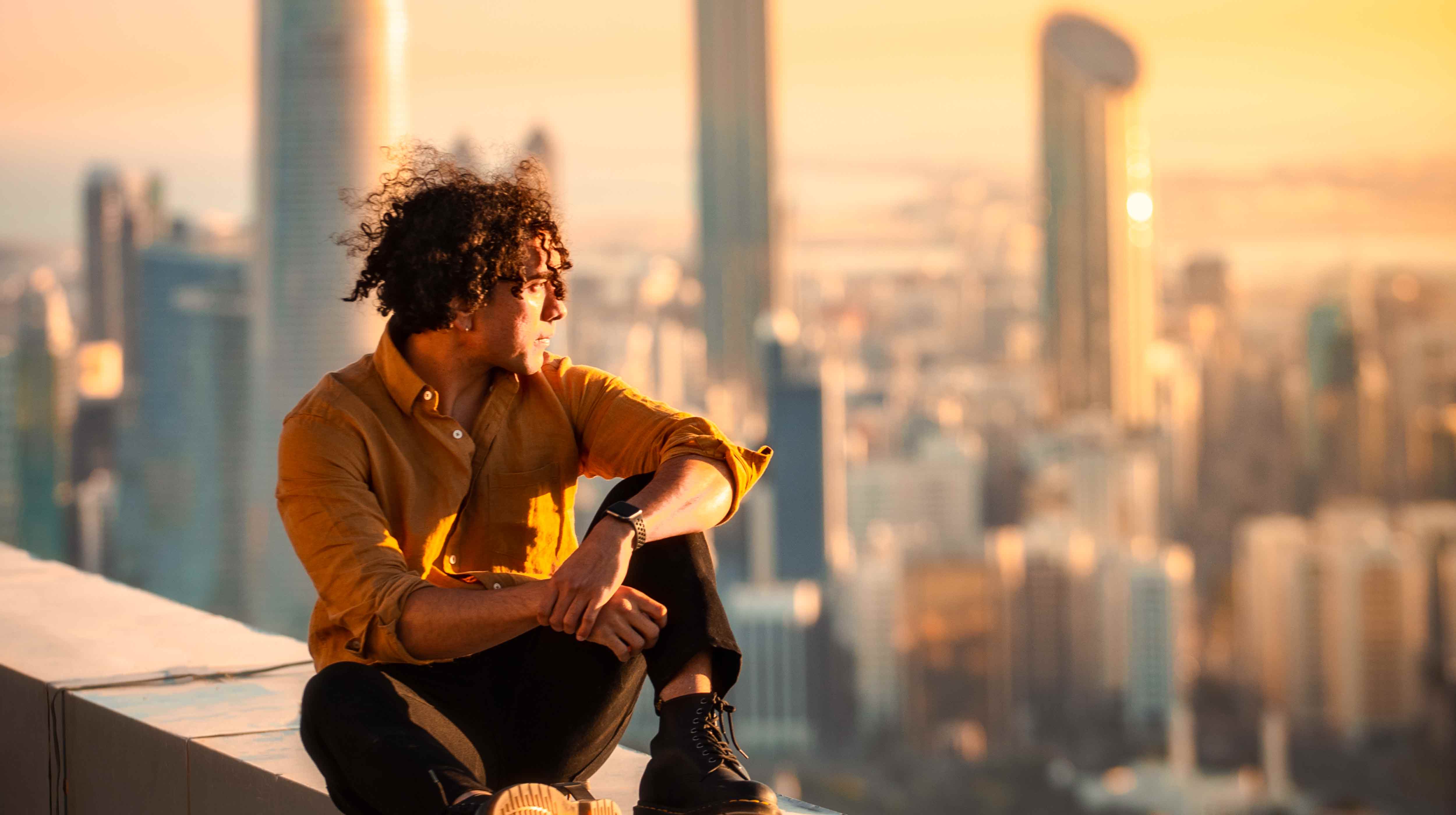 Jeune homme adulte profitant de la vie urbaine à Abu Dhabi avec des gratte-ciel en arrière-plan.