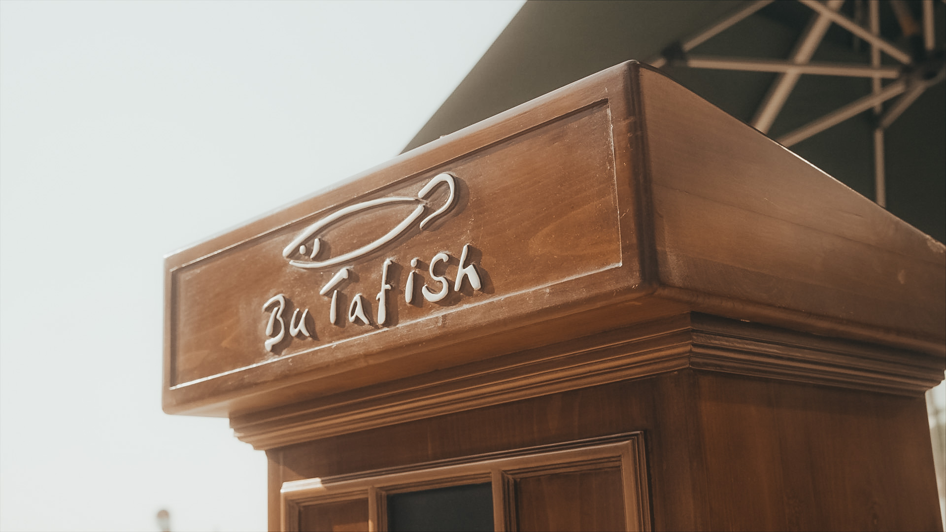 Logo of Bu Tafish on a wooden kiosk