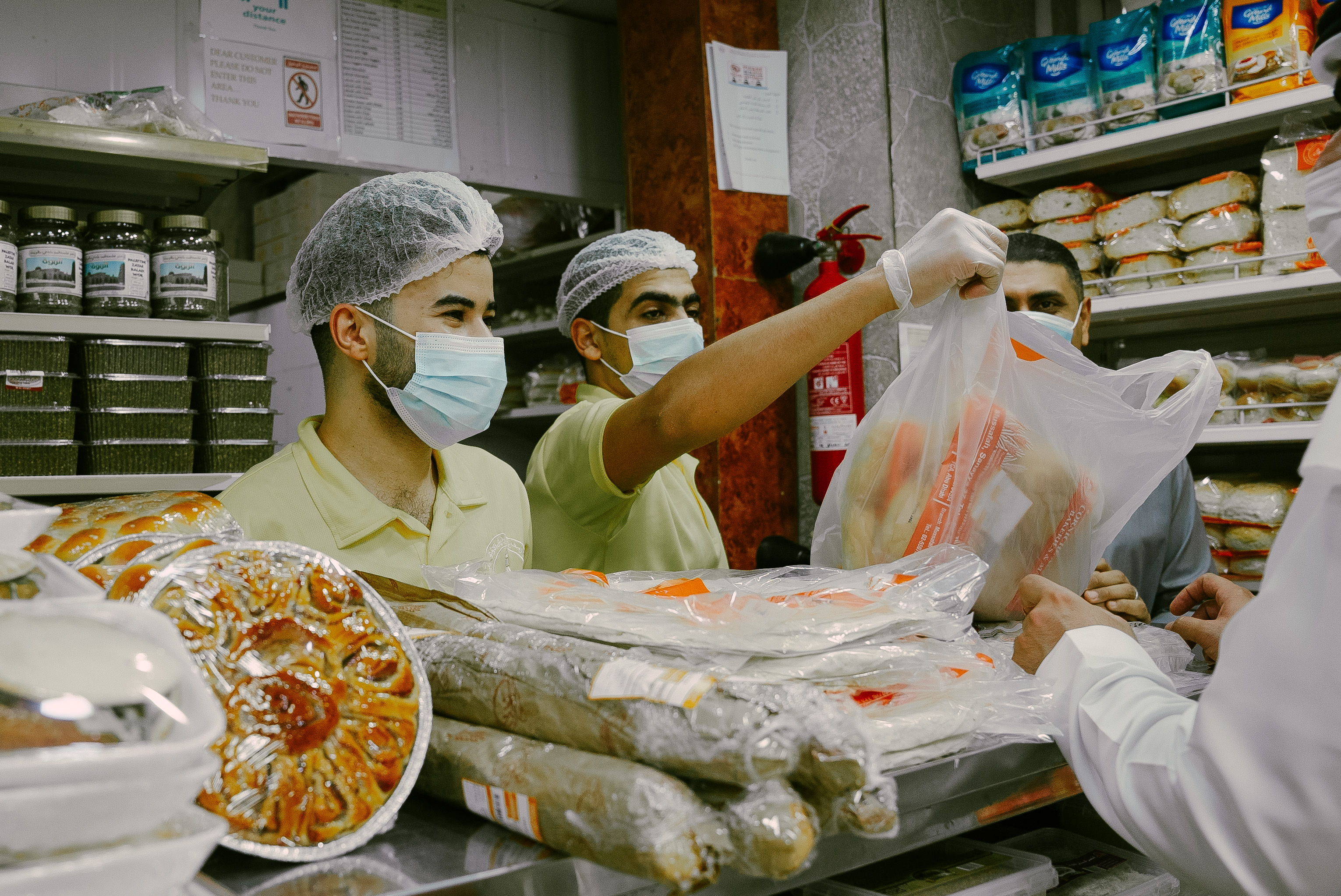 Two shopkeeper selling baked goods at Corniche Automatic Bakeries and Markets