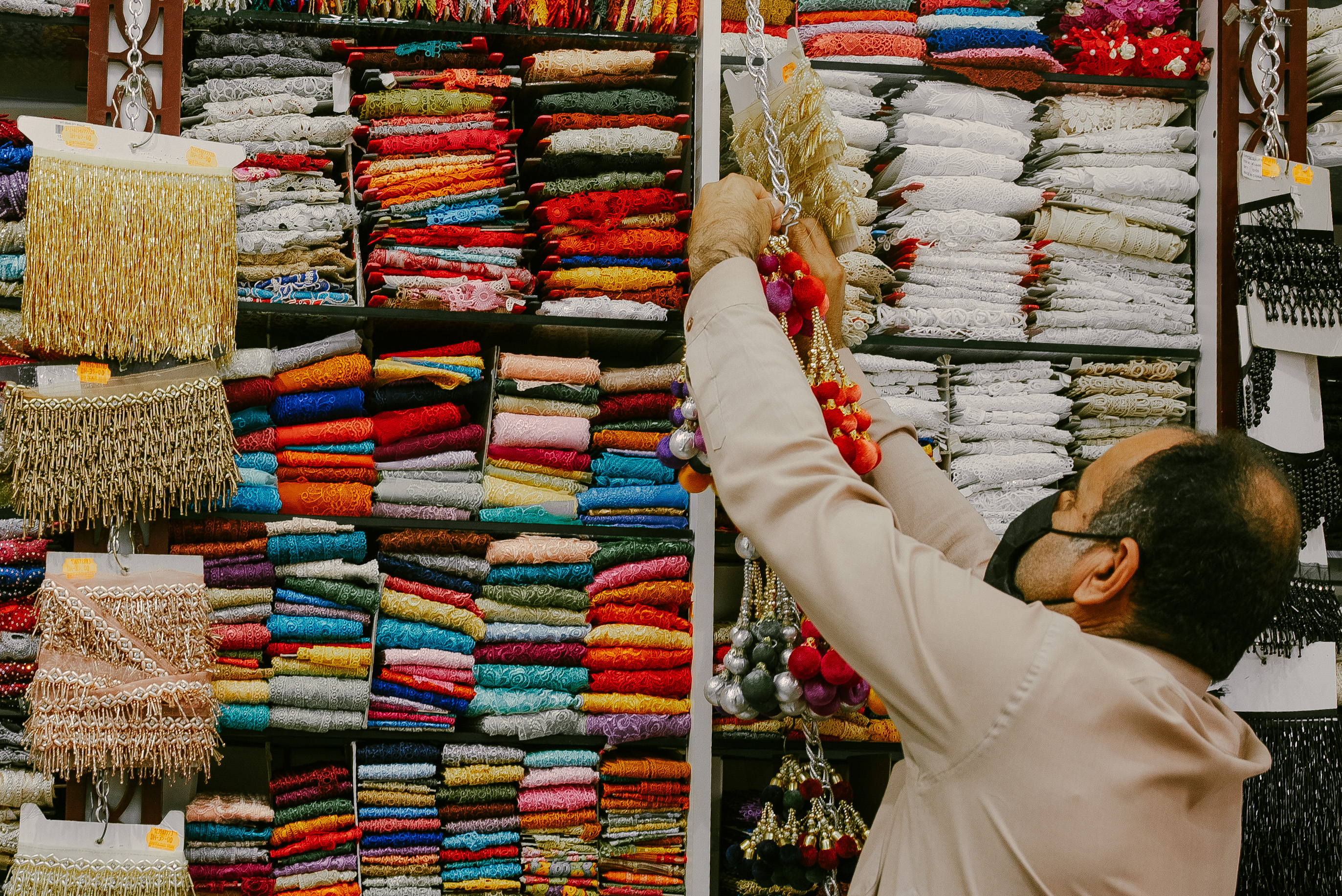 Shopkeeper in a mask at Malik and Shaheed Stores