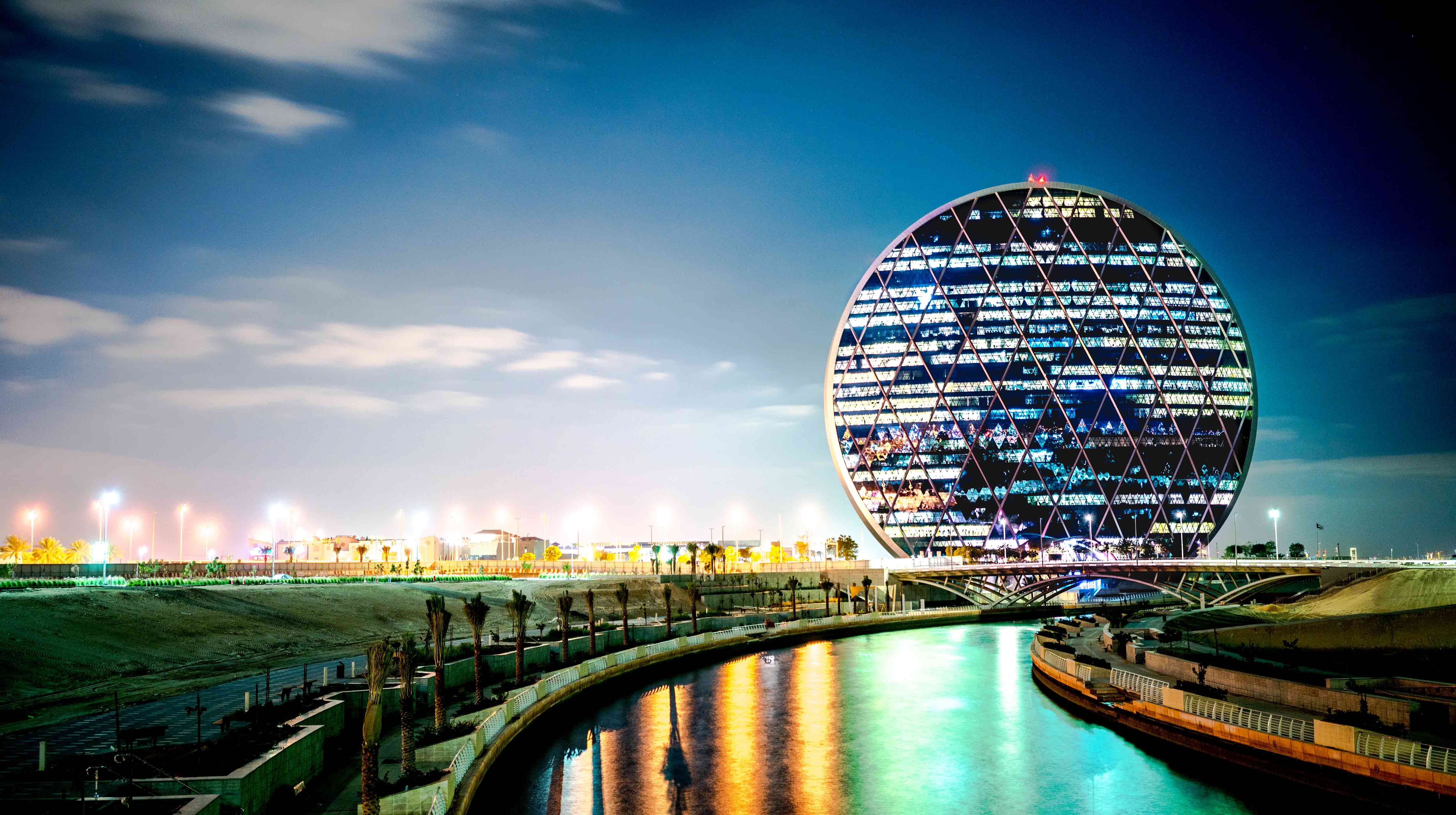 مبنى الدرهم الأيقوني والمعروف بكونه مقر لشركة الدار العقارية في أبوظبي وراء مجرىً لمياه البحر بين جزر أبوظبي