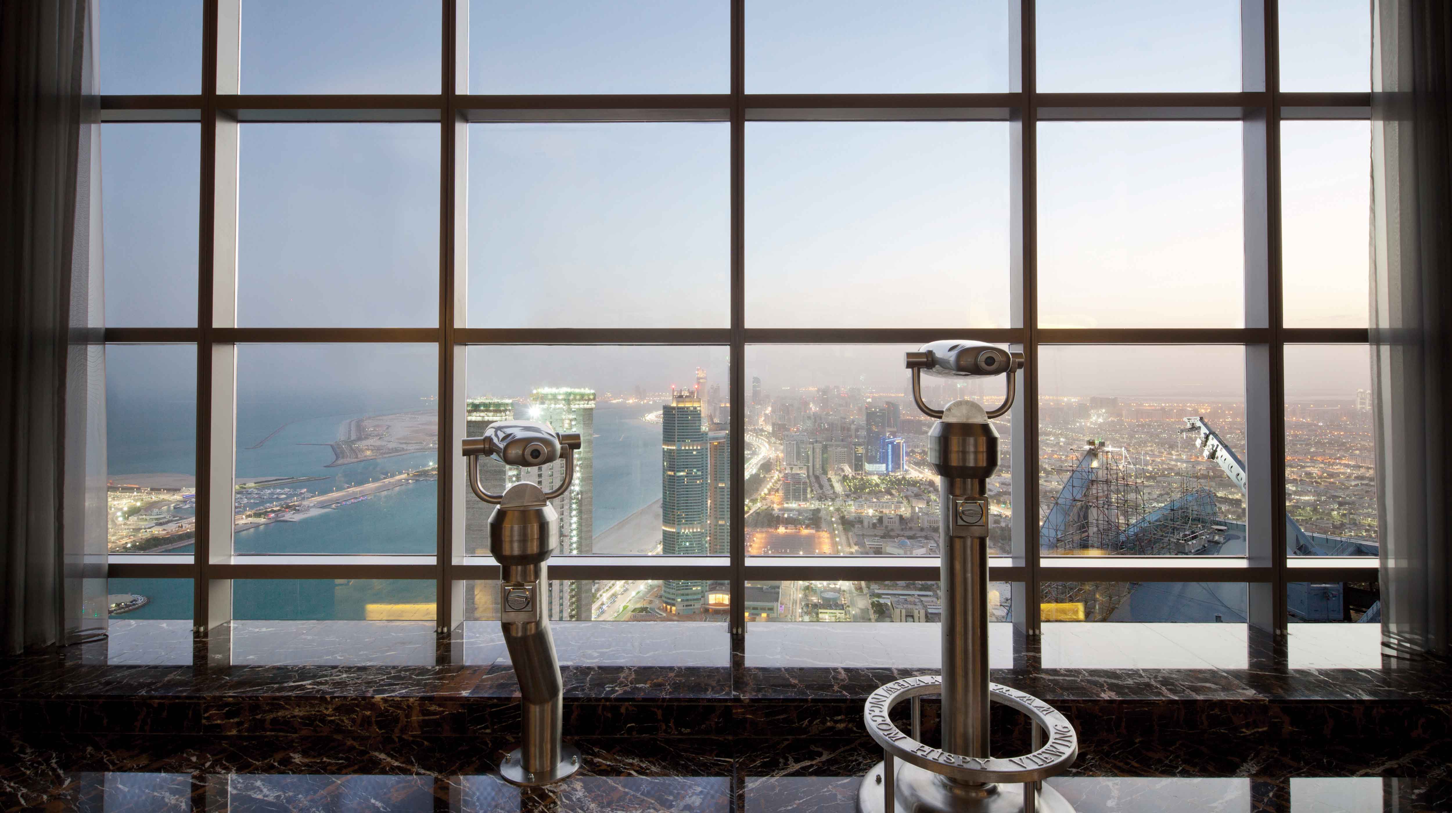 Vista su Abu Dhabi dal Observation Deck at 300. Ci sono due binocoli.